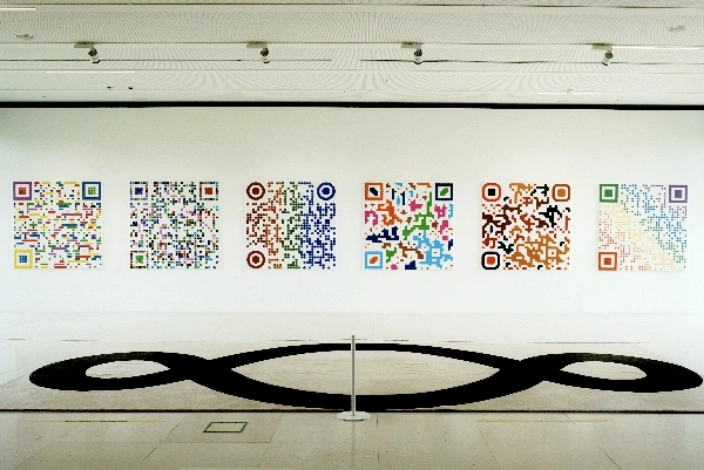 Bunte QR-Codes an einer weißen Wand – Symbol für kreative Bewertungsstrategien und digitale Sichtbarkeit von Handwerksbetrieben