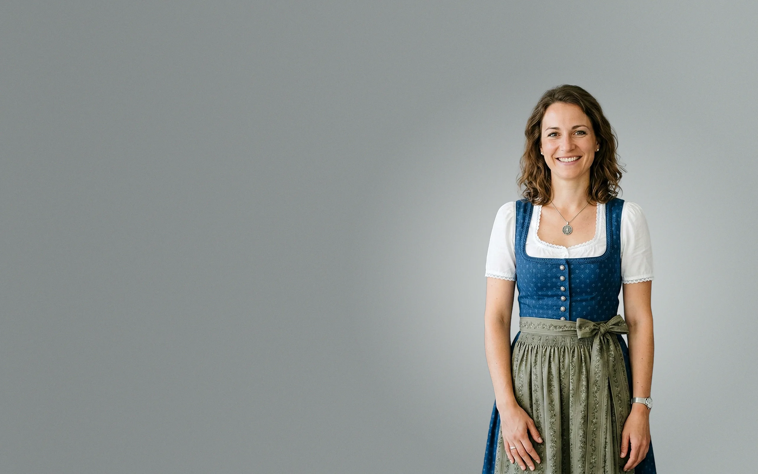 Fröhliche Münchner Kundin im blauen Dirndl nach erfolgreicher Google Ads Kampagne.