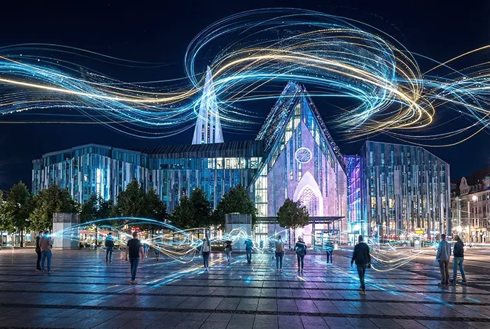 Futuristische Langzeitbelichtung des Leipziger Augustusplatzes und Paulinum bei Nacht mit digitalen Lichtspuren.