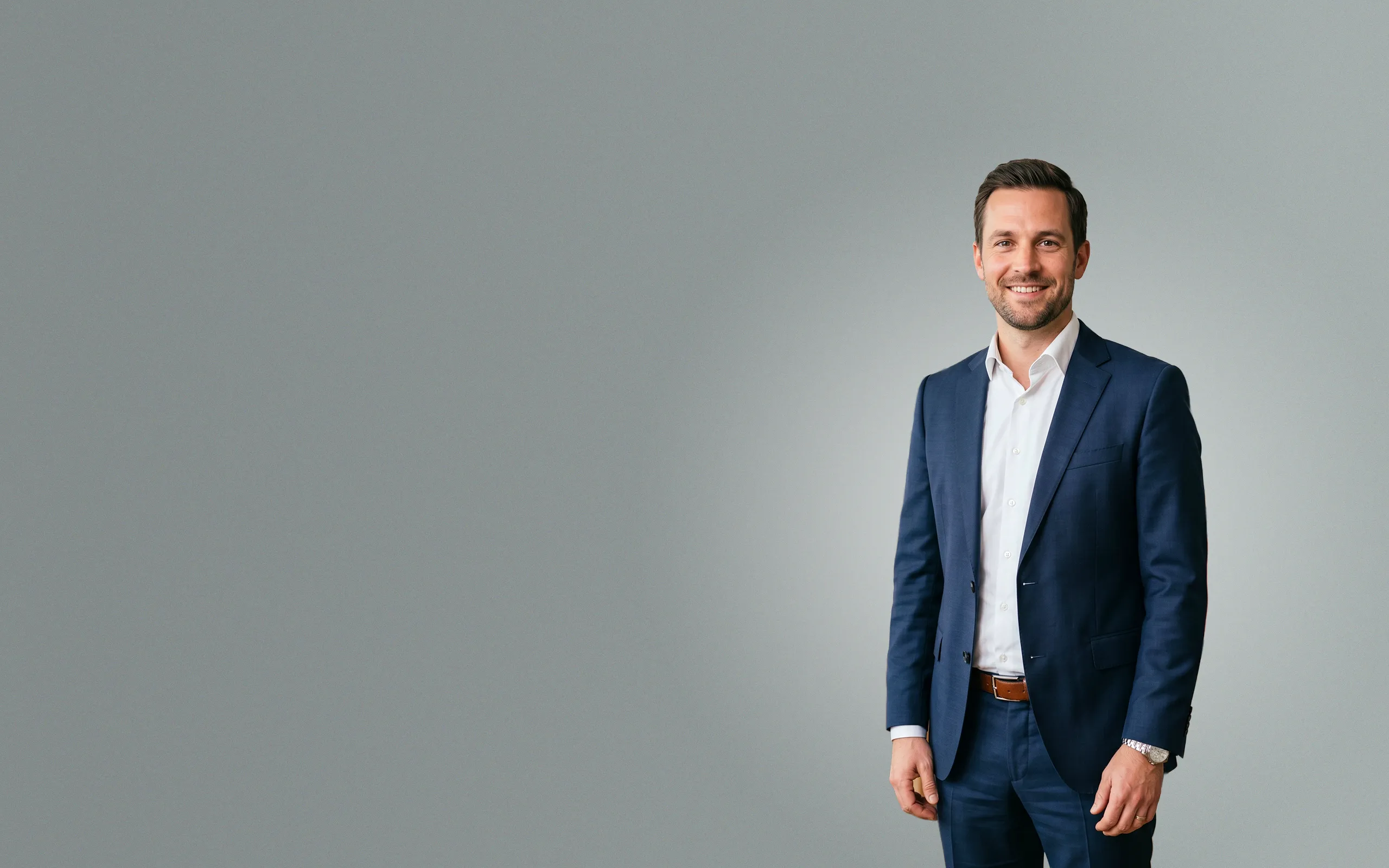 Seriöser Rechtsanwalt im dunkelblauen Anzug lächelt in die Kamera – Symbolbild für SEO, SEA und professionelles Webdesign für Kanzleien und Berater.