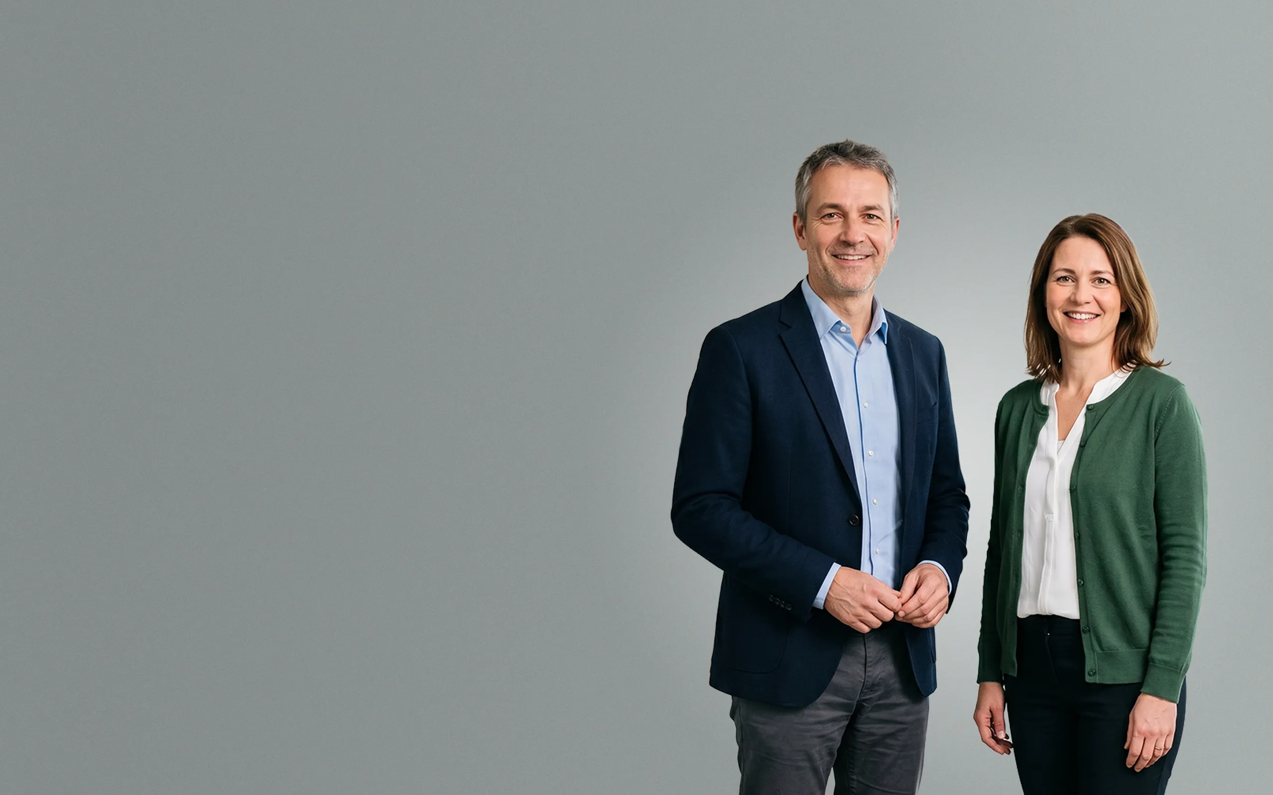 Professionelles Geschäftsführungs-Duo lächelt in die Kamera – Symbolbild für B2B-Marketing, SEO, Google Ads und Webdesign für den Mittelstand (KMU).