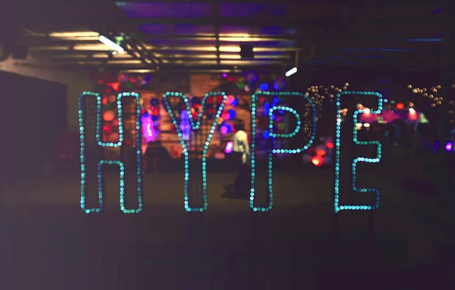 Ein leuchtender Neon-Schriftzug mit dem Wort "HYPE" in einer abgedunkelten Halle.