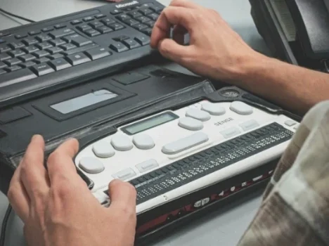 Eine Person nutzt einen Screenreader auf einem Laptop, um eine barrierefreie Website zu navigieren.