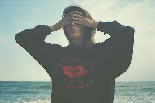 Frau am Strand mit zugehaltenen Augen als Metapher für Google Ads ohne Conversion-Tracking.
