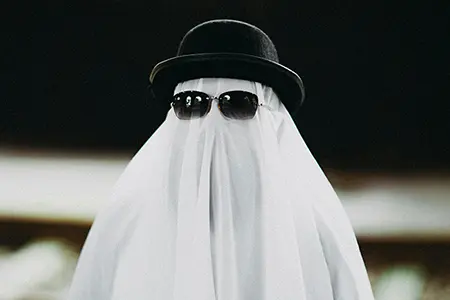 Ein Geist mit Melone und Sonnenbrille, der Unsichtbarkeit und Anonymität symbolisiert.